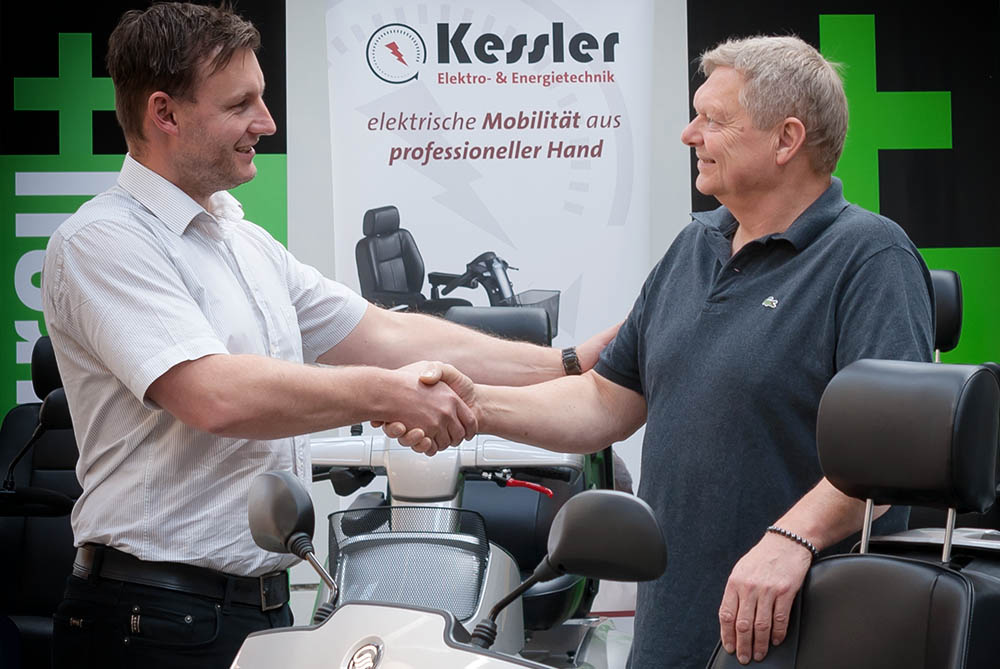 Elektromobilverkauf wird mit Handschlag besiegelt